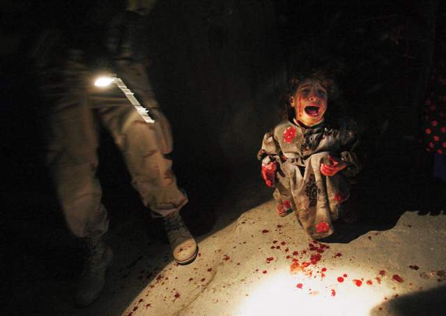 Иракская девочка на контрольно-пропускном пункте, Крис Хондрос, 2005. Родители Саман Хасан везли её брата из больницы, когда американские солдаты открыли по ним огонь. Солдаты боялись, что в машине были террористы-смертники и застрелили их. Только потом они увидели, что это была мирная семья.