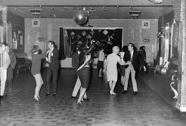 Битлз поют для 18 человек в скромном клубе городка Олдершот в декабре 1961 года. Через полтора года они станут мега-звездами.