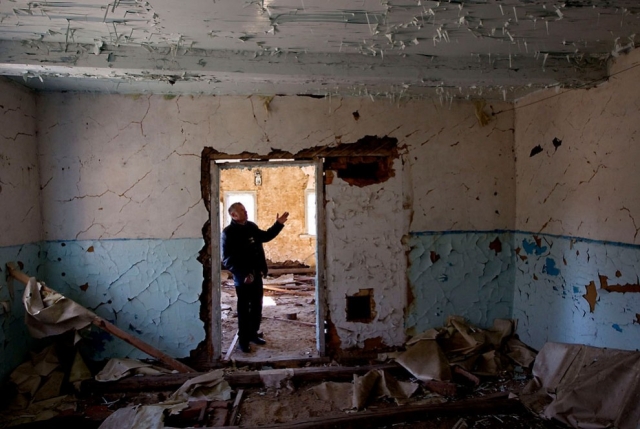 А это мужчина в своем бывшем доме в запретной зоне вокруг Чернобыля, в поселке Ломыш, на юго-востоке от Минска, 18 марта 2011 года.