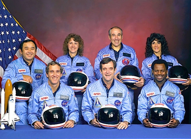 В экипаж шаттла входили семь человек, в том числе один астронавт-непрофессионал - бывшая учительница, выигравшая в конкурсе право лететь в космос.