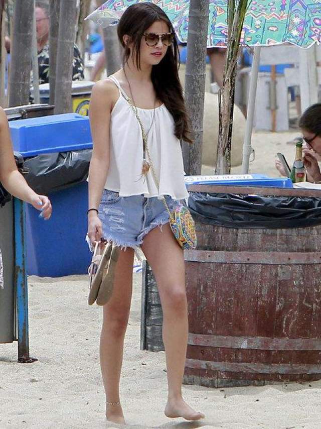 Селена Гомес прогуливается босиком по песку после обеда в "Paradise Cove" в Малибу, 23 июня 2013 года. Звезда "Волшебников из Уэйверли" носит в такую летнюю пору короткие шорты и майку. 