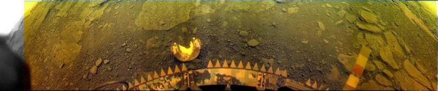 Панорама поверхности Венеры в месте посадки аппарата "Венера-13". В центре - посадочный буфер аппарата с зубцами турбулизатора, обеспечивающего плавную посадку, выше - сброшенная белая полуцилиндрическая крышка окна телевизионной камеры. Ее диаметр 20 см, высота 16 см. Расстояние между зубцами 5 см.