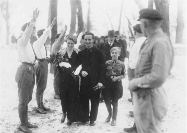 На втором плане можно рассмотреть Гитлера, ставшего гостем на свадьбе Геббельса.