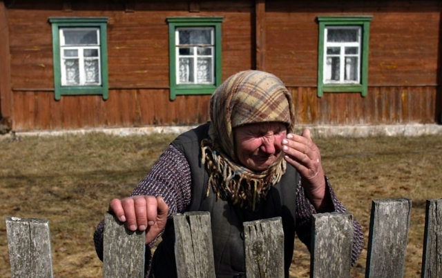 Плачущая 67-летняя Настасия Васильева у своего дома в пострадавшей от катастрофы деревне Радныя в запретной зоне, в 45 км от Чернобыльской АЭС.