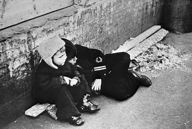 Дети сидят возле каменной стены. 1 октября 1942 года.