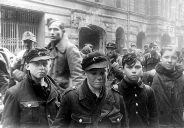 Колонна пленных на улице Берлина. На переднем плане "последняя надежда Германии" мальчишки из гитлерюгенда и фольксштурма